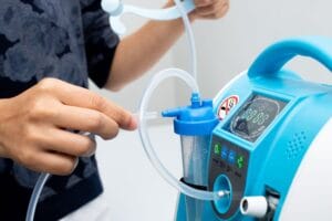 A person attaching a medical-grade silicone tube to a medical machine.